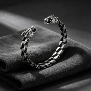 Close-up of vintage titanium steel dragon head cuff with braided leather cord details