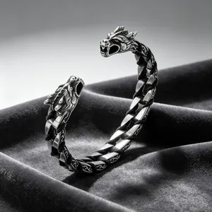 Close-up of double dragon head steel bangle with woven leather detail and antique finish.