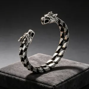Detail view of vintage titanium steel double dragon head open bracelet with black rope