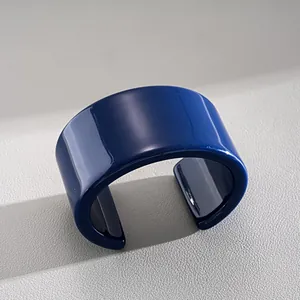 Detailansicht eines glänzenden dunkelblauen Armreifs auf strukturiertem Grund