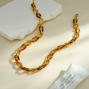 Macro detail of amber resin links and gold chain on textured white stone background