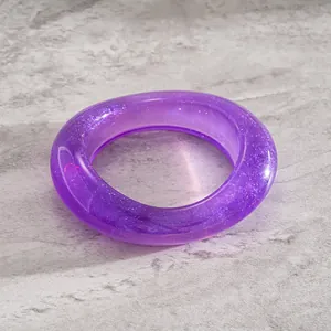 Detailed view of a purple translucent resin bangle with sparkling glitter flakes.