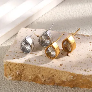 Détail rapproché d'élégantes boucles d'oreilles goutte en zircone plaquées or 18K