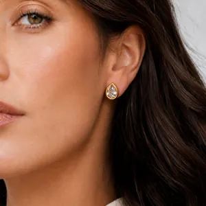 Gros plan d'élégantes boucles d'oreilles gouttes en zircon plaqué or 18 carats sur un modèle