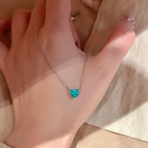 Exquisite Nahaufnahme einer Silberhalskette mit herzförmigem grünem Zirkonanhänger