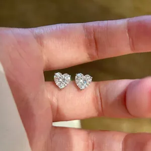 Elegante koreanische Ohrstecker mit funkelnden Zirkonia-Herzen auf den Fingern
