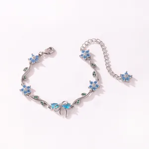 Vue détaillée du bracelet argenté avec fleurs et nœud en zircone bleue