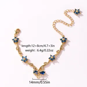 Bracelet élégant plaqué or orné de fleurs en zircon bleu et d'un motif nœud délicat.