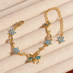 Gros plan d'un bracelet en or orné de fleurs en zircon bleu et de feuilles de papillon