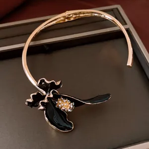 Primo piano dettagliato di girocollo vintage con fiore in smalto nero e strass brillanti