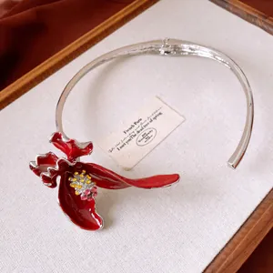 Primo piano del girocollo a fiore in smalto rosso con strass scintillanti in stile retrò.