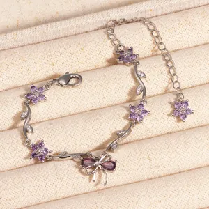 Vue détaillée du bracelet en argent avec des fleurs en zircon violet et nœud