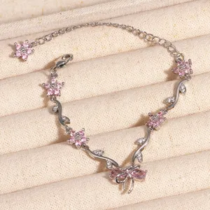 Vue détaillée d'un bracelet exquis avec cerisier en fleurs en zircon rose et noeud