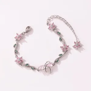 Détail d'un élégant bracelet en argent avec des fleurs en zircon rose et un nœud