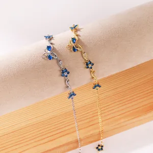 Vue détaillée des bracelets papillon et feuilles en zircone bleue sur présentoir.