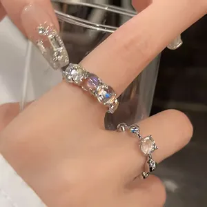 Close-up view of elegant sparkling round zircon open rings worn on woman's fingers