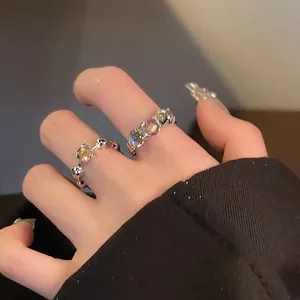 Macro view showing the iridescent sparkle of round cubic zirconia open rings on model's fingers