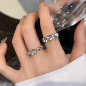 Close-up of sparkling round zirconia rings on hand in light-reflecting style