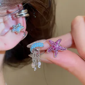 Close-up view of exquisite zircon-encrusted starfish ear cuffs with delicate chain details.
