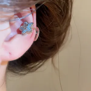 Detailed macro view of a silver starfish ear cuff set with sparkling blue zircons.