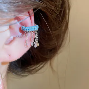 Detail of blue beaded ear cuff with silver chain tassels and clear crystal charms