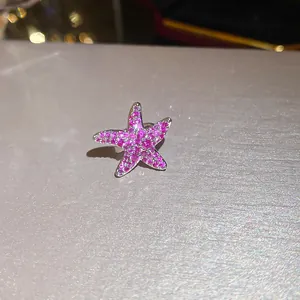 Macro detail of a sparkling pink zircon starfish ear cuff with no piercing design