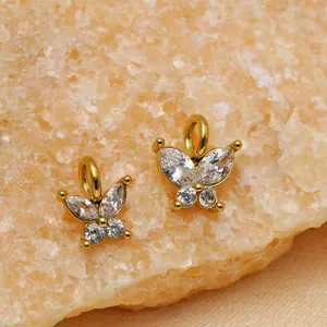 Close-up detail of butterfly pendants with sparkling zircons on a natural stone