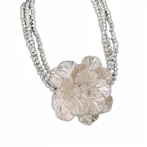 Elegant multi-layer beaded statement necklace featuring a large metallic flower pendant.