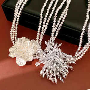 Detailed macro view of a luxury silver multi-layer beaded necklace with elegant flower pendant