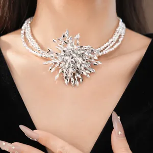 Detailed view of an exaggerated multilayered beaded necklace with a spiky flower pendant