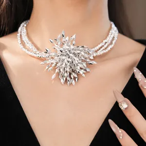 Close-up detail of a layered beaded choker necklace with an exaggerated crystal flower pendant