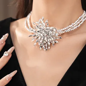 Close-up of a silver multi-strand beaded statement necklace with a spiky flower pendant