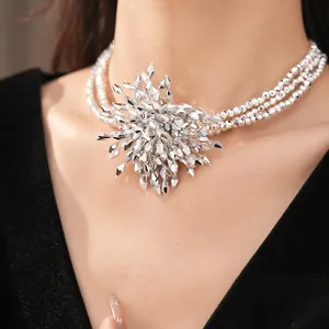 Detailed close-up of multi-layer beaded necklace with oversized faceted silver flower.
