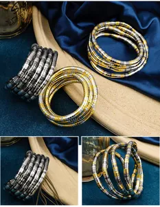 Close-up detail of flexible gold and silver snake wrap necklace and bracelet set.