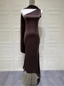 Detail view of an elegant one-shoulder brown satin evening gown on a mannequin pro