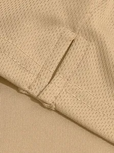 Close-up detail of khaki tactical polo shirt showing bird-eye fabric and side slit