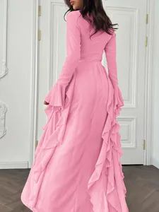 Détail de la vue arrière d'une robe maxi rose à manches longues et volants latéraux