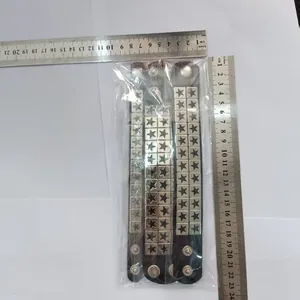 Detailed view of punk black leather bracelets with star rivets and measurement rulers