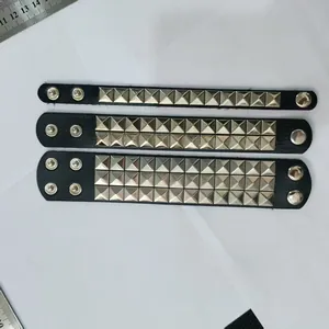 Detail of punk PU leather wristbands with one, two, and three rows of square studs