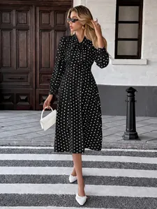 Abito midi vintage a pois bianchi e neri con colletto a fiocco e maniche lunghe.