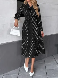 Robe midi vintage noire à pois avec col à nœud et manches longues, vue en pied complète