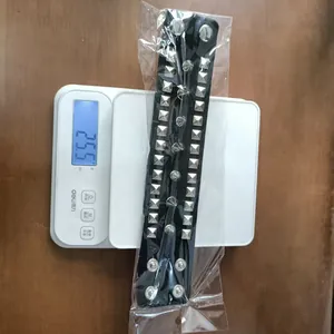 Close-up view of a punk-style PU leather bracelet with silver rivets on a digital scale.