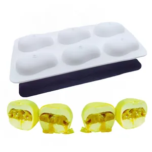 Detail view of a white 6-cavity silicone baking mold with finished yellow mousse desserts