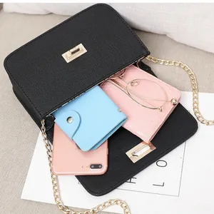 Stylish black leatherette chain crossbody square bag showing interior storage capacity
