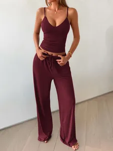Model wearing wine red camisole and wide leg trousers lounge set in indoor setting