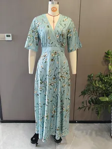 Close-up detail of an elegant light blue V-neck maxi dress with floral patterns