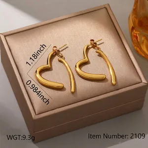 Close-up of heart-shaped gold-plated stainless steel earrings on a luxury jewelry box.