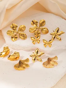 Detailed view of gold stainless steel earrings with butterfly, flower, and leaf shapes