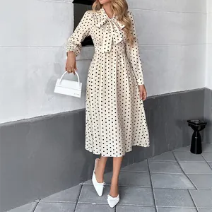 Elegante abito midi a pois con scollo a fiocco e maniche lunghe