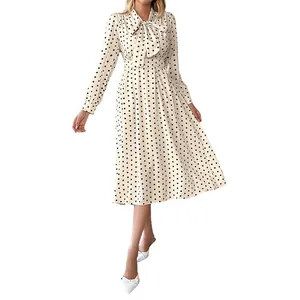Elegante abito midi a pois a maniche lunghe con collo a fiocco e vita stretta.